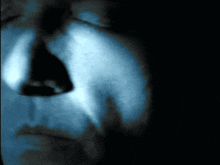 a close up of a person 's face with a blue light shining on it