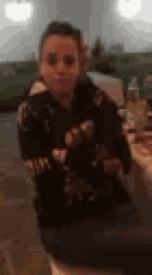 a blurry picture of a young boy sitting at a table eating food .
