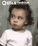 a little girl is making a funny face while wearing a white t-shirt .