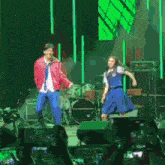 a man and a woman are dancing on stage in front of a crowd