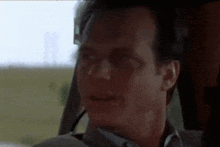 a close up of a man 's face in a car with a blurred background