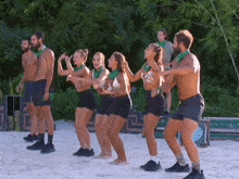 a group of people are dancing on a beach