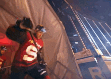 a hockey player in a red jersey with the number 5 on it