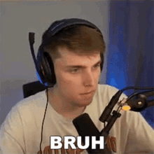 a man wearing headphones is sitting in front of a microphone and making a funny face .