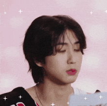 a close up of a person 's face with a pink background and stars .