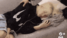 a person is laying on a bed with their head on a pillow while a person holds their arm .