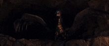 a man is holding a sword in front of a large black monster in the dark .