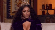 the woman is wearing a tiara and a purple dress .