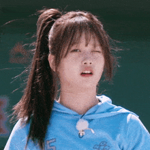a girl with a ponytail wearing a blue shirt with the number 15 on it