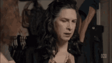 a woman with long hair is making a funny face in a closet .