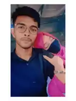 a man wearing glasses and a woman wearing a pink hijab pose for a photo