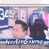 a man is sitting in front of a screen that says wayupgaming