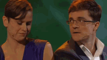 a man and a woman are sitting next to each other and the woman is wearing a microphone