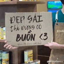 a person is holding a cardboard sign that says " dep gai " on it