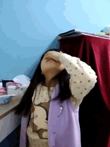 a girl wearing a purple shirt with a monkey on it
