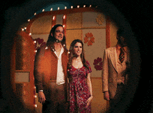 a woman in a red dress is standing next to a man in a suit