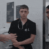 a man with a stethoscope around his neck is talking to another man