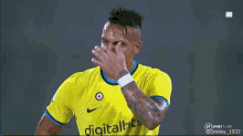 a soccer player wearing a yellow shirt with digitalbet on it