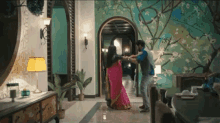 a woman in a pink saree is dancing with a man in a blue shirt