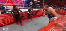 a group of wrestlers are wrestling in a ring .