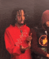 a man in a red hoodie has the letter a on the front