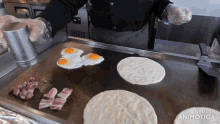eggs and bacon are being cooked on a griddle with the words made in animatica visible