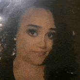a close up of a woman 's face with curly hair making a face .