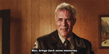 a man in a uniform says " man brings back some memories " in front of a wooden wall