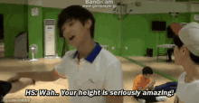 a man in a white shirt says " wah your height is seriously amazing " in front of a mirror