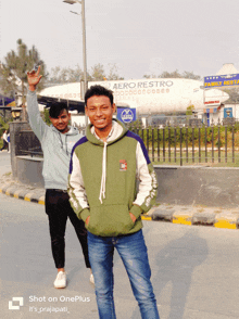 two young men are posing for a picture in front of an aero restro plane