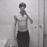 a shirtless man is taking a picture of himself in a bathroom mirror