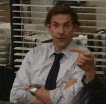a man in a shirt and tie is pointing at something