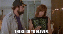 a man and a woman are standing next to each other and the woman is wearing a skeleton tank top .