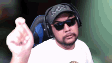 a man wearing headphones and sunglasses is pointing his finger