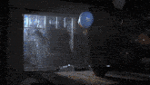 a blue balloon is floating in the air in a dark room