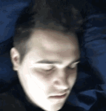 a close up of a man 's face with a blue background .