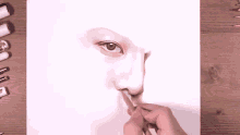 a person is drawing a woman 's eye with a pencil