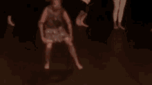 a group of people are dancing in a dark room without shoes on