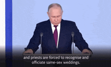 a man in a suit and tie is standing at a podium giving a speech