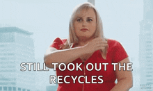 a woman in a red shirt is holding her hair and says `` still took out the recycle '' .