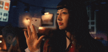 a woman is holding a playing card with the ace of hearts on it