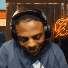 a man wearing headphones is sitting in front of a lightning bolt .