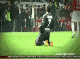 a soccer player wearing a number 7 jersey is kneeling on the field