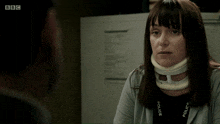 a woman wearing a neck brace talks to a man on bbc