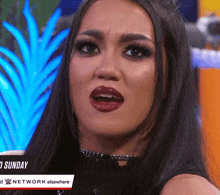 a close up of a woman 's face in front of a sign that says sunday on it