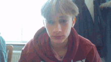 a young boy wearing a red sweatshirt that says abercrombie