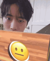 a man looking at a laptop with a smiley face on the screen