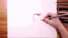 a person drawing a woman 's eye with colored pencils