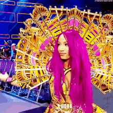 a woman with purple hair is wearing a crown and a gold dress .