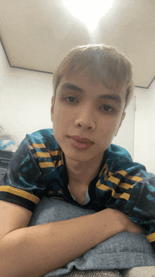 a young man in a blue and yellow shirt with a star on the sleeve